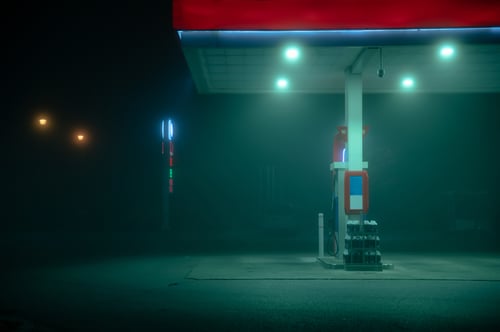 Empty gas pump during a foggy night with glowing lights
