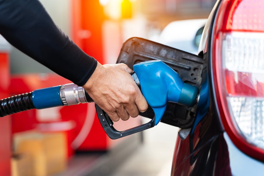 Man's hand pumping gasoline into a car
