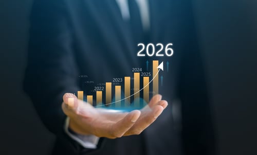 Businessman with digital arrow graph with 2026 year number showing business growth
