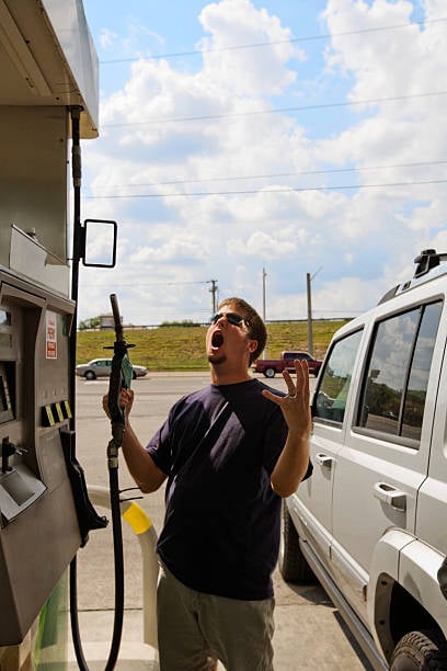 man pumping gas, upset about high gas prices